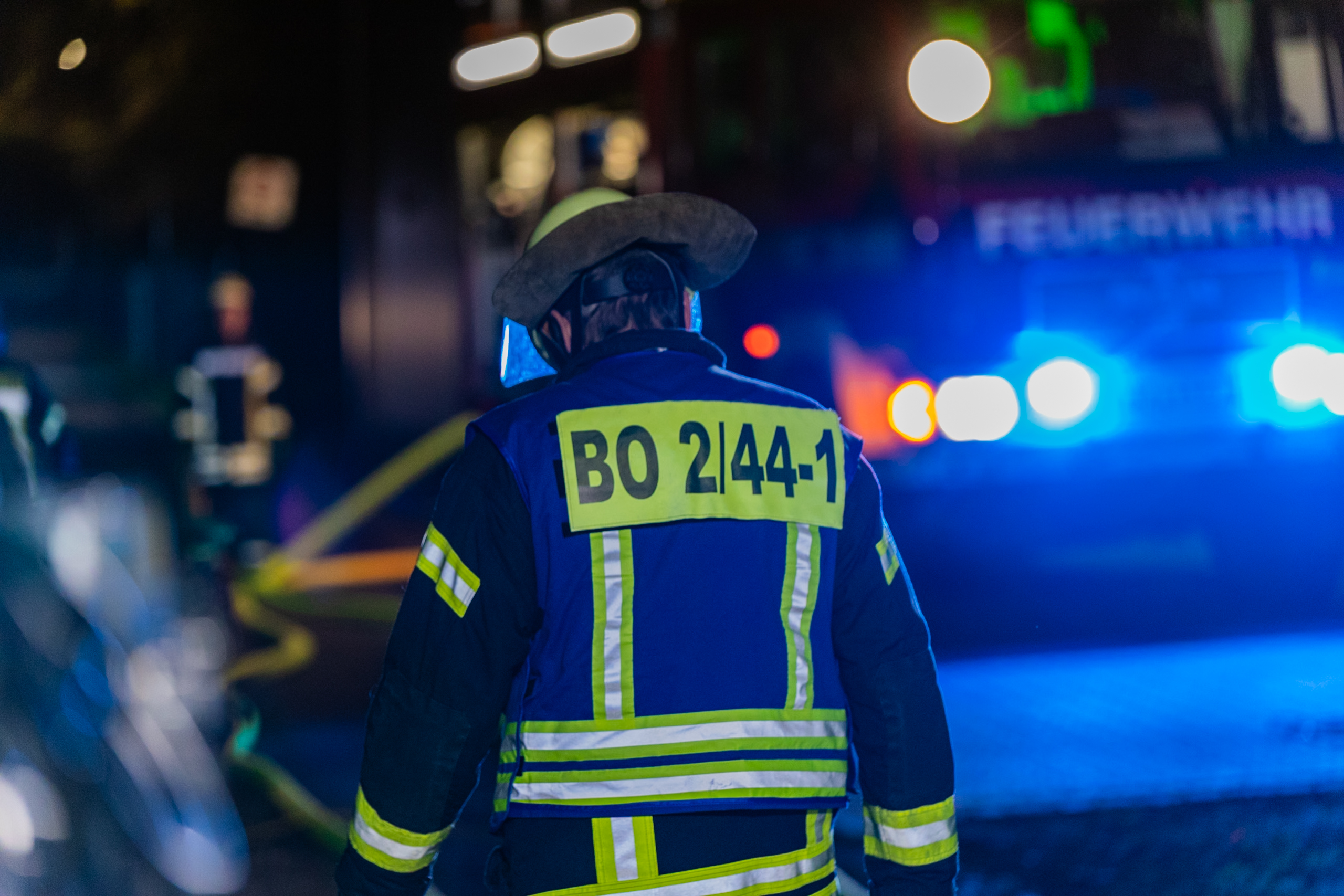 Feuerwehrkraft bei Nacht vor Blaulicht