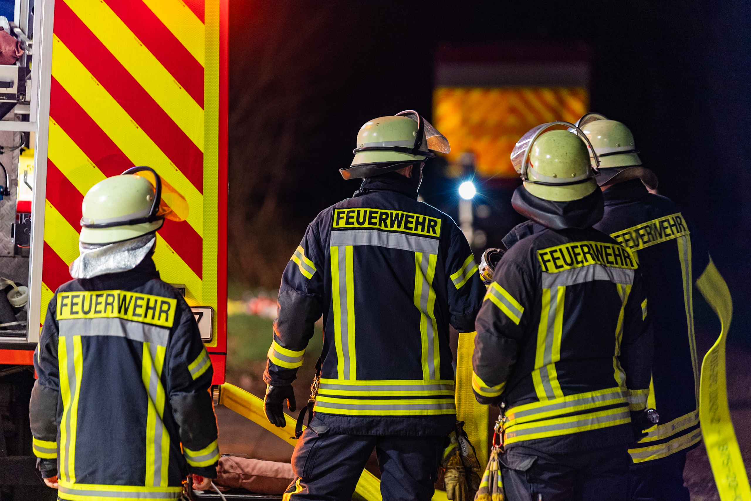 Feuerwehrkräfte in Schutzkleidung an einem Fahrzeug